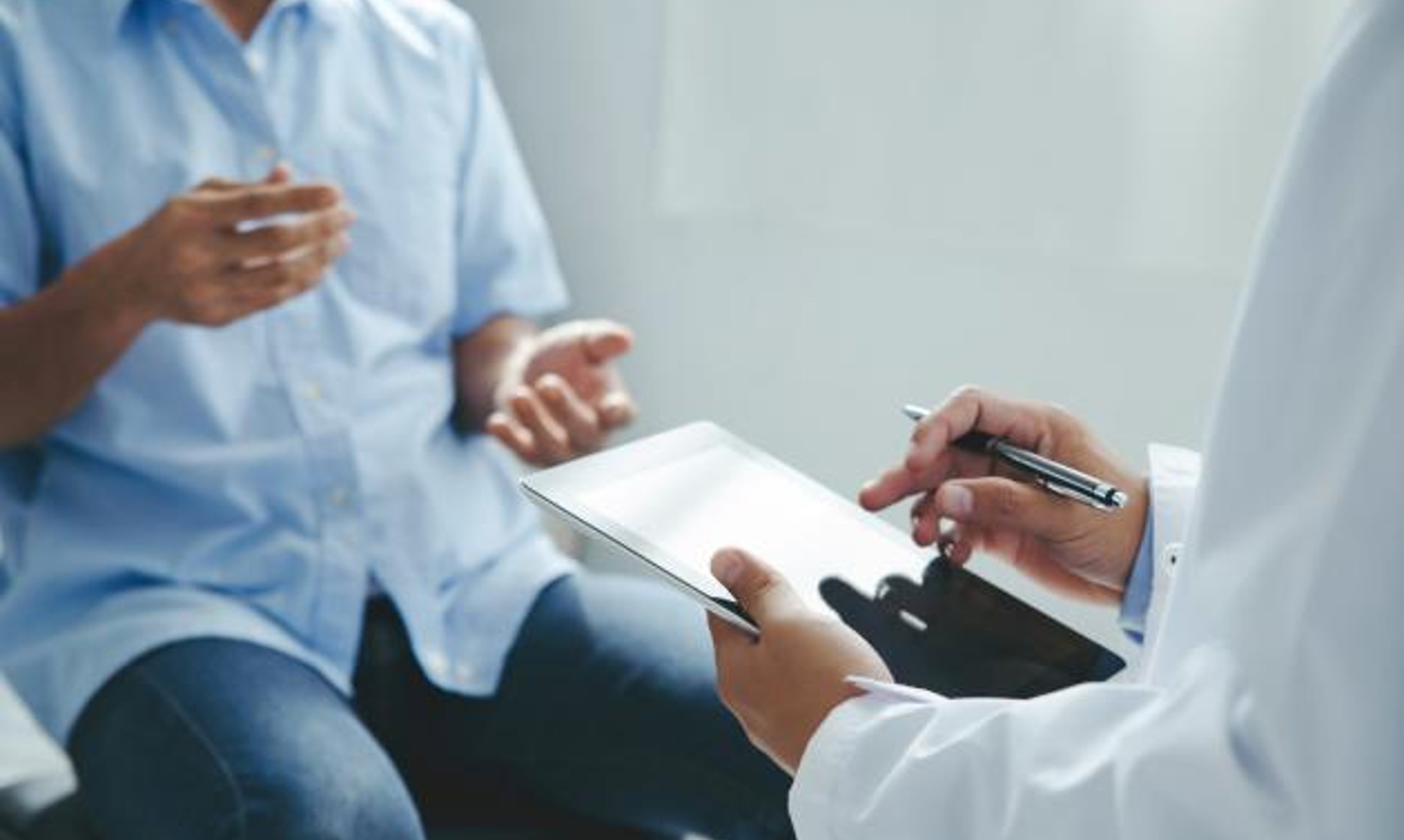 Doctor explaining something to a seated patient