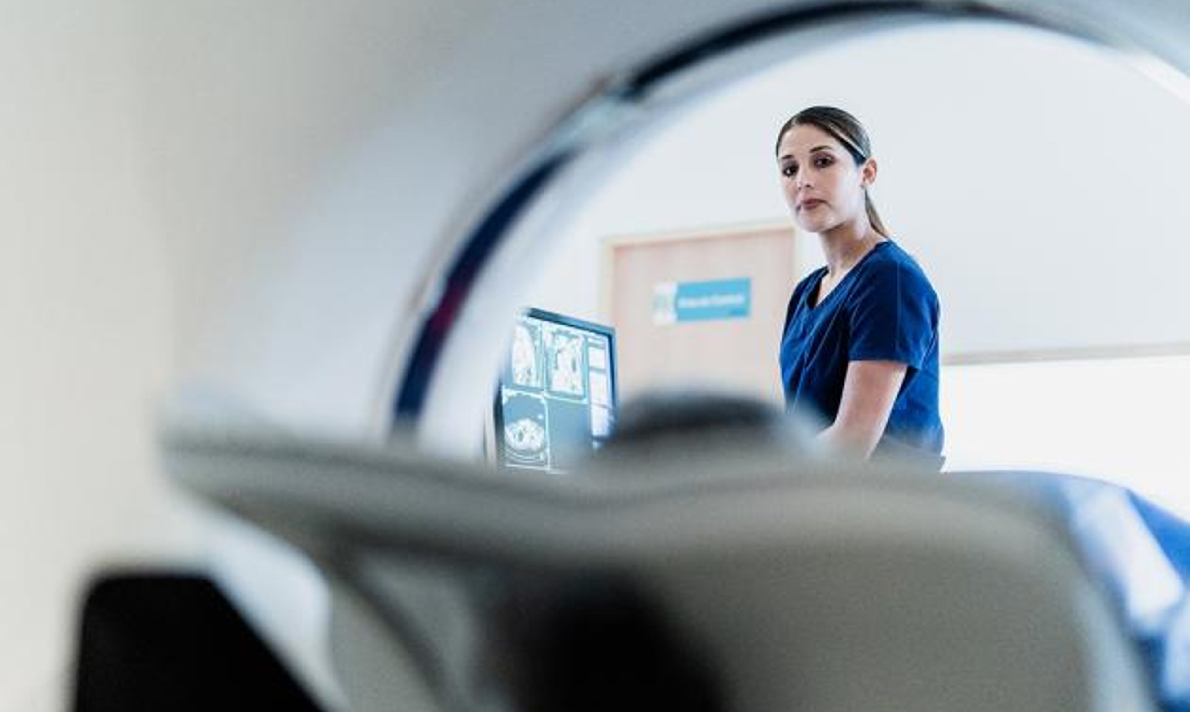 A hospital worker looks on during an MRI.