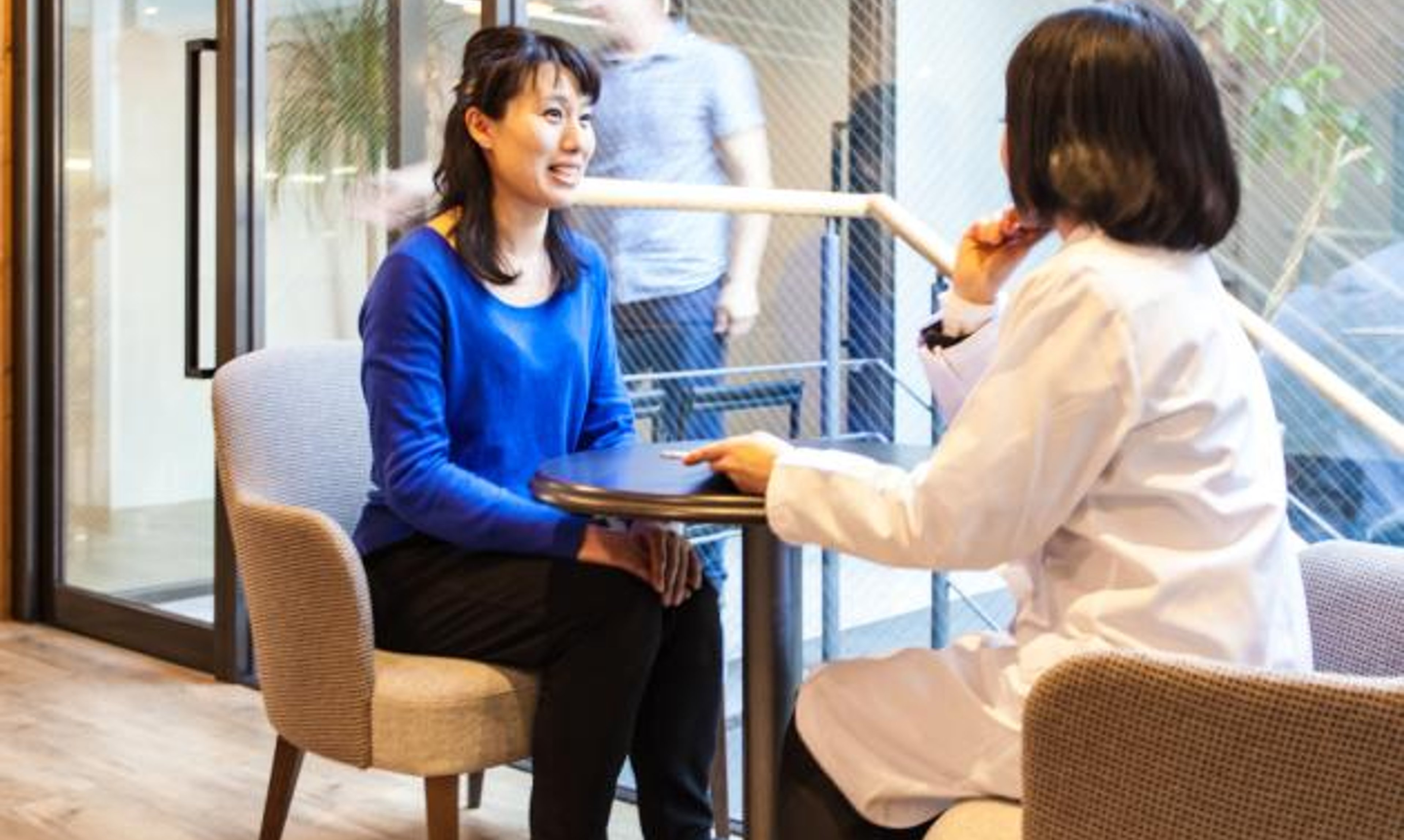 A person in a lab talks with a doctor.