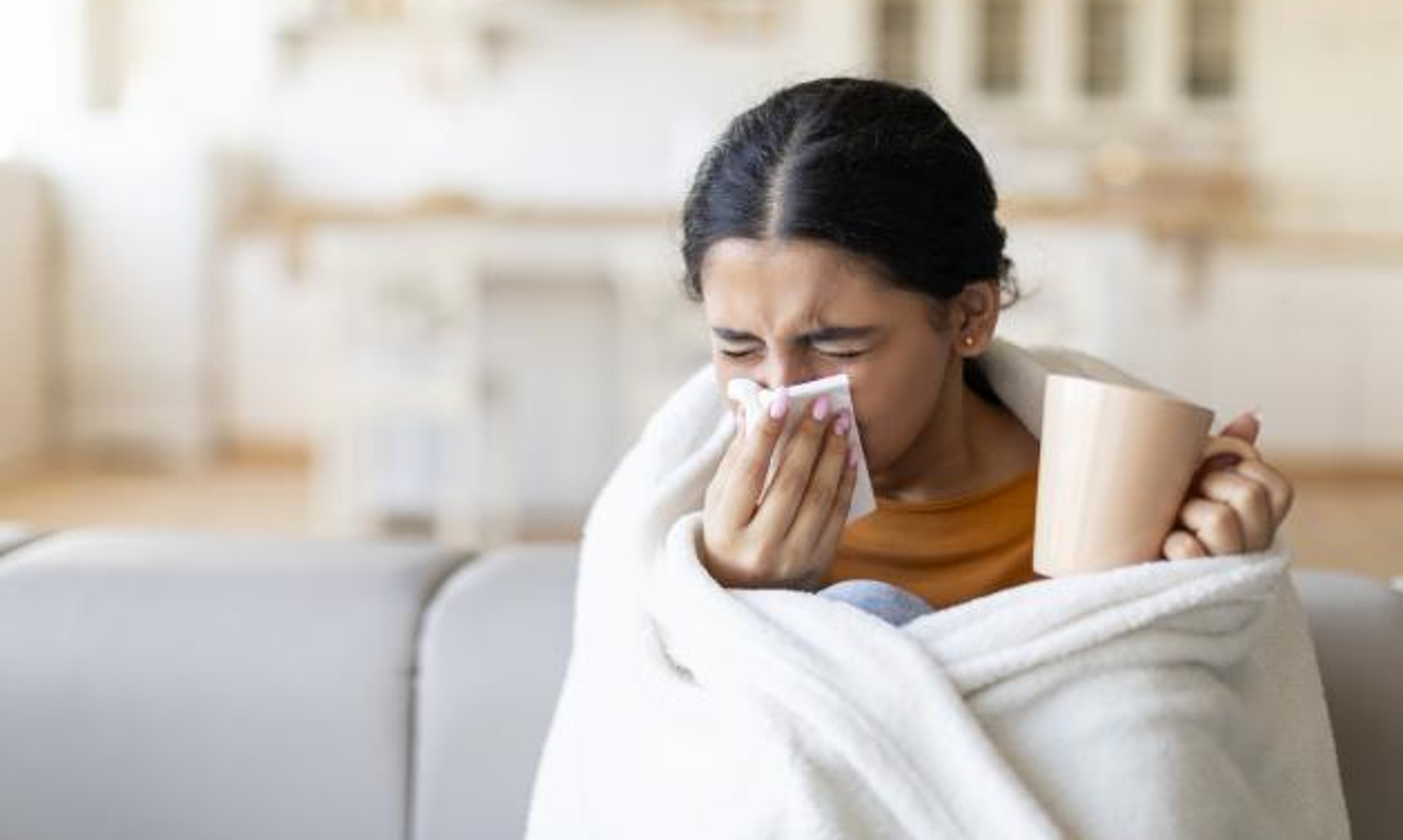 sick young woman blowing nose