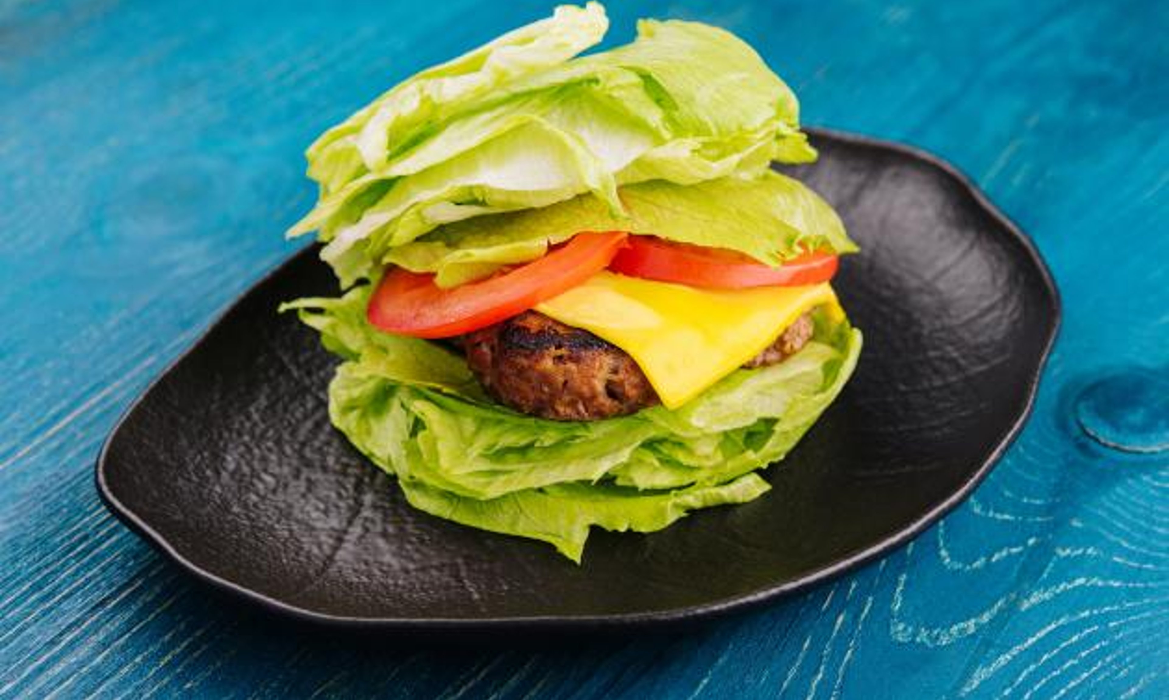 Lettuce-wrapped smash and fry burger on a plate