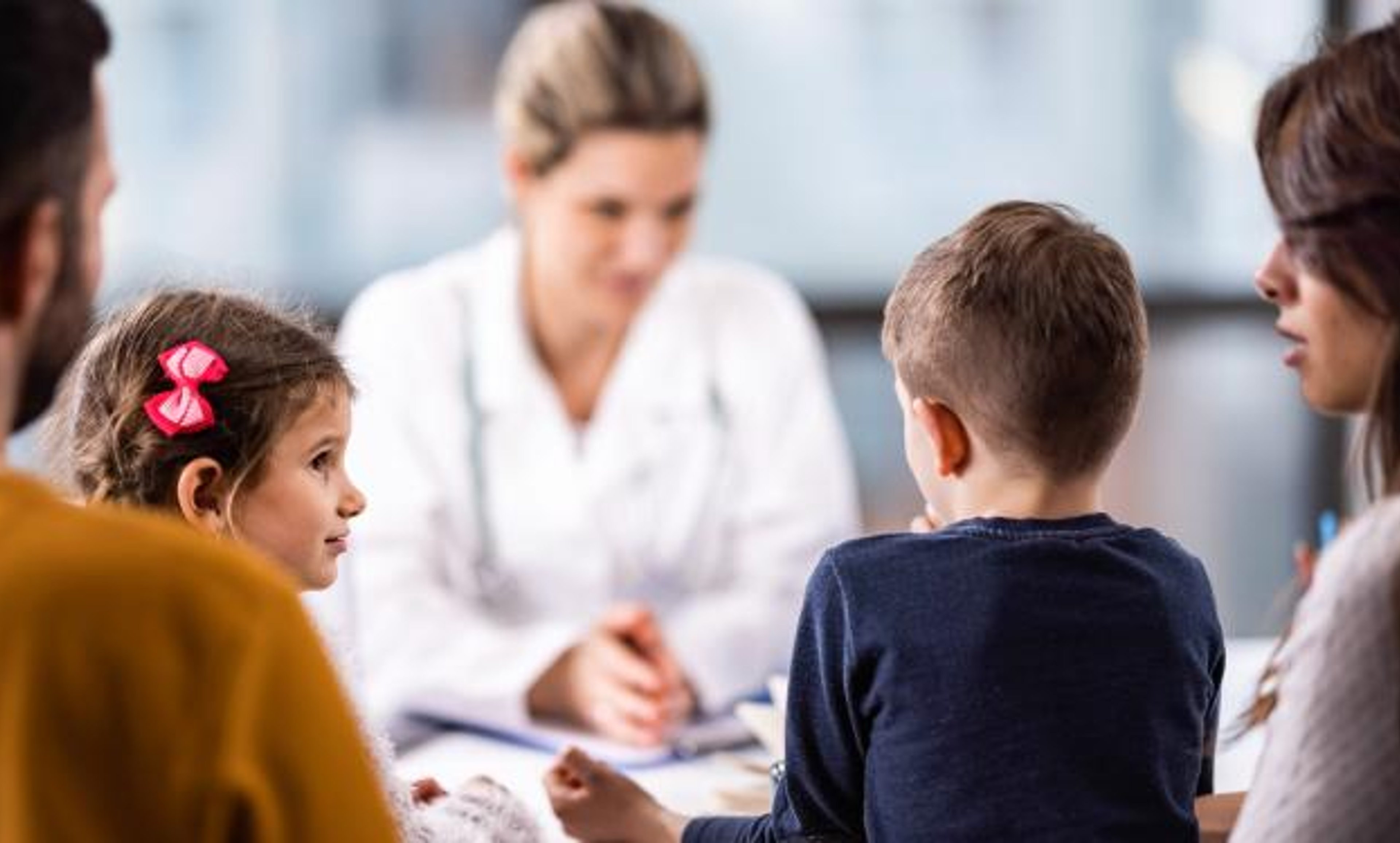 Healthcare professional talking to man and woman with two kids