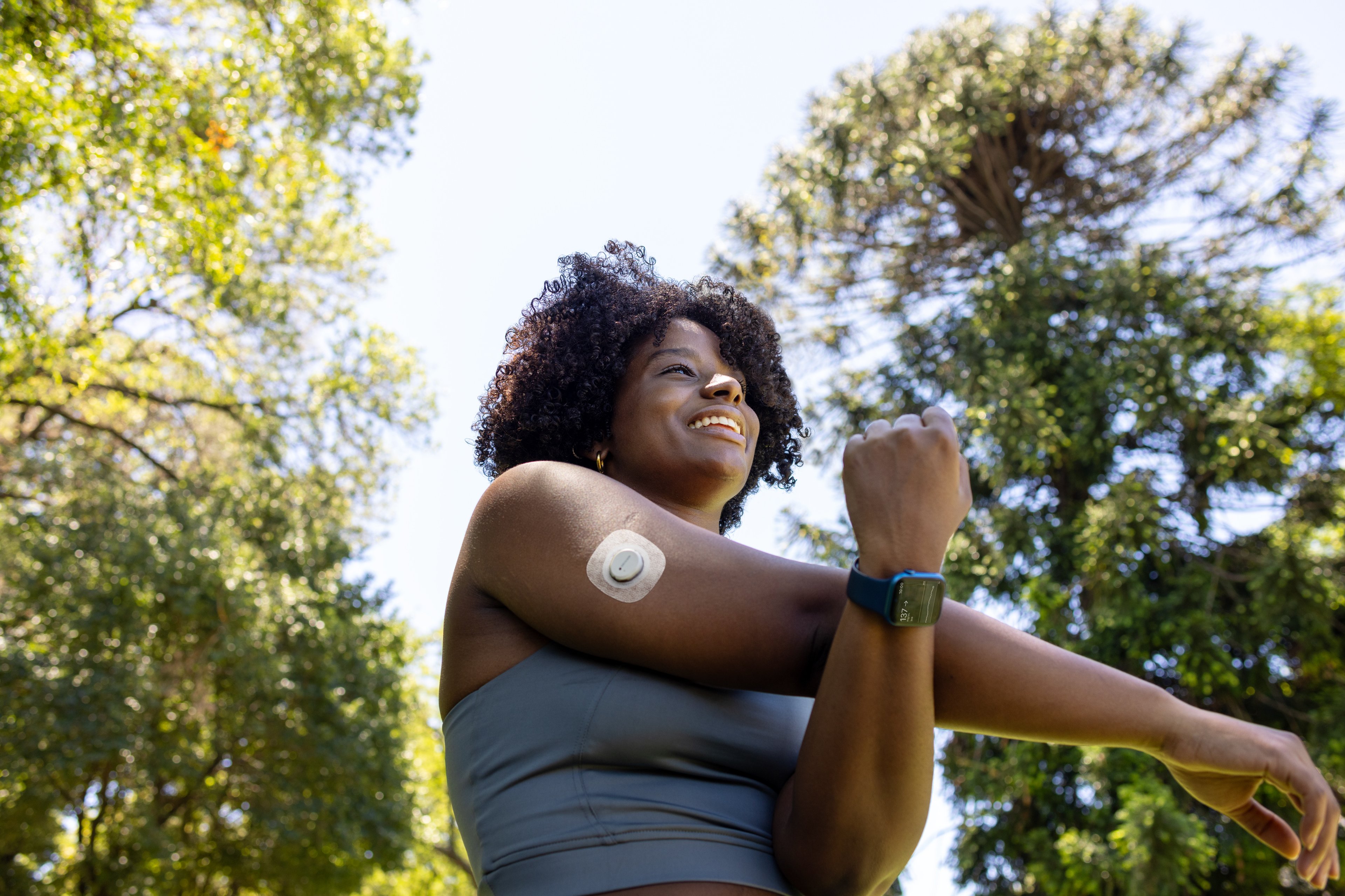 Woman stretching arm wearing G7 CGM and an Apple Watch