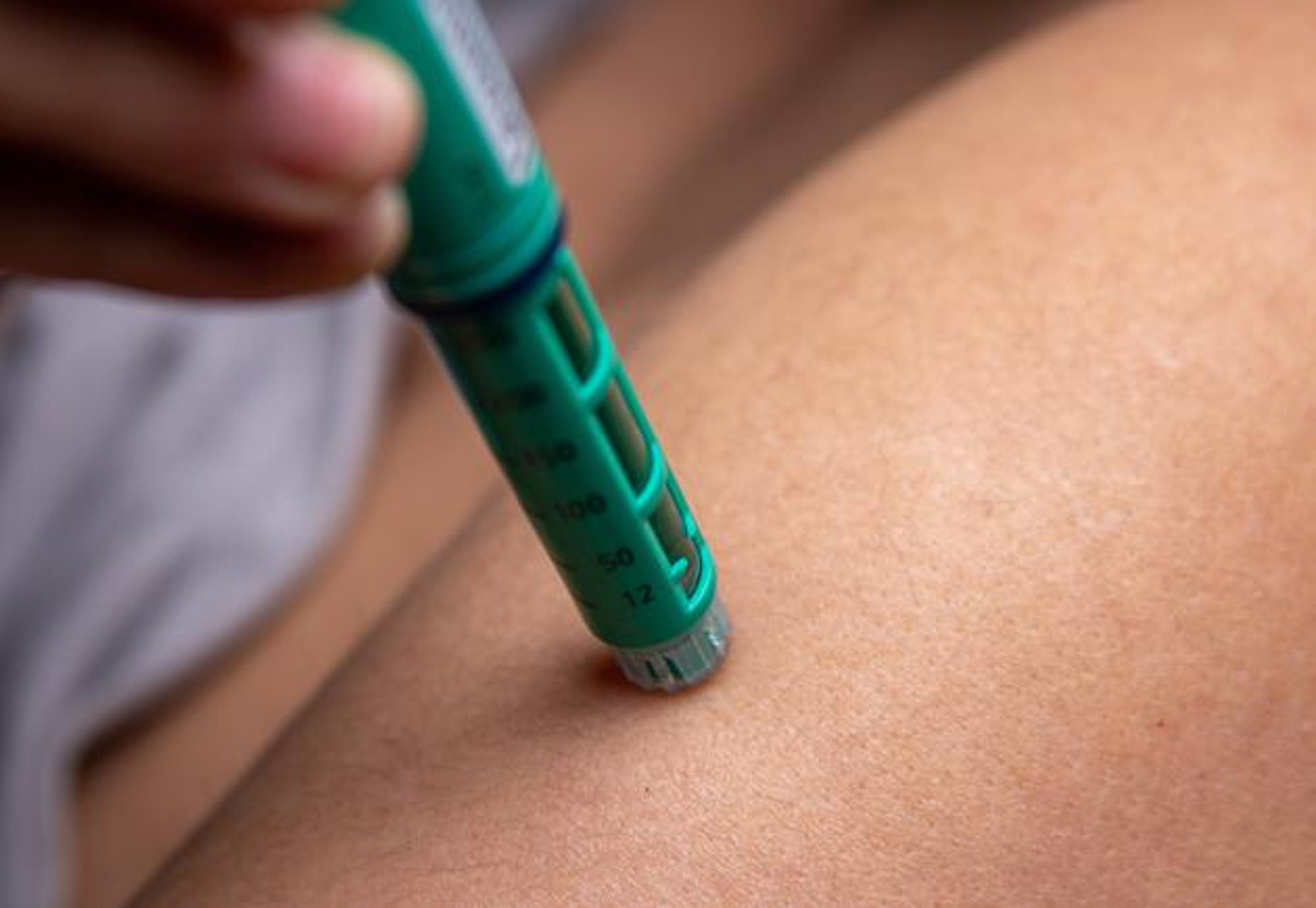 A person injects insulin into their body