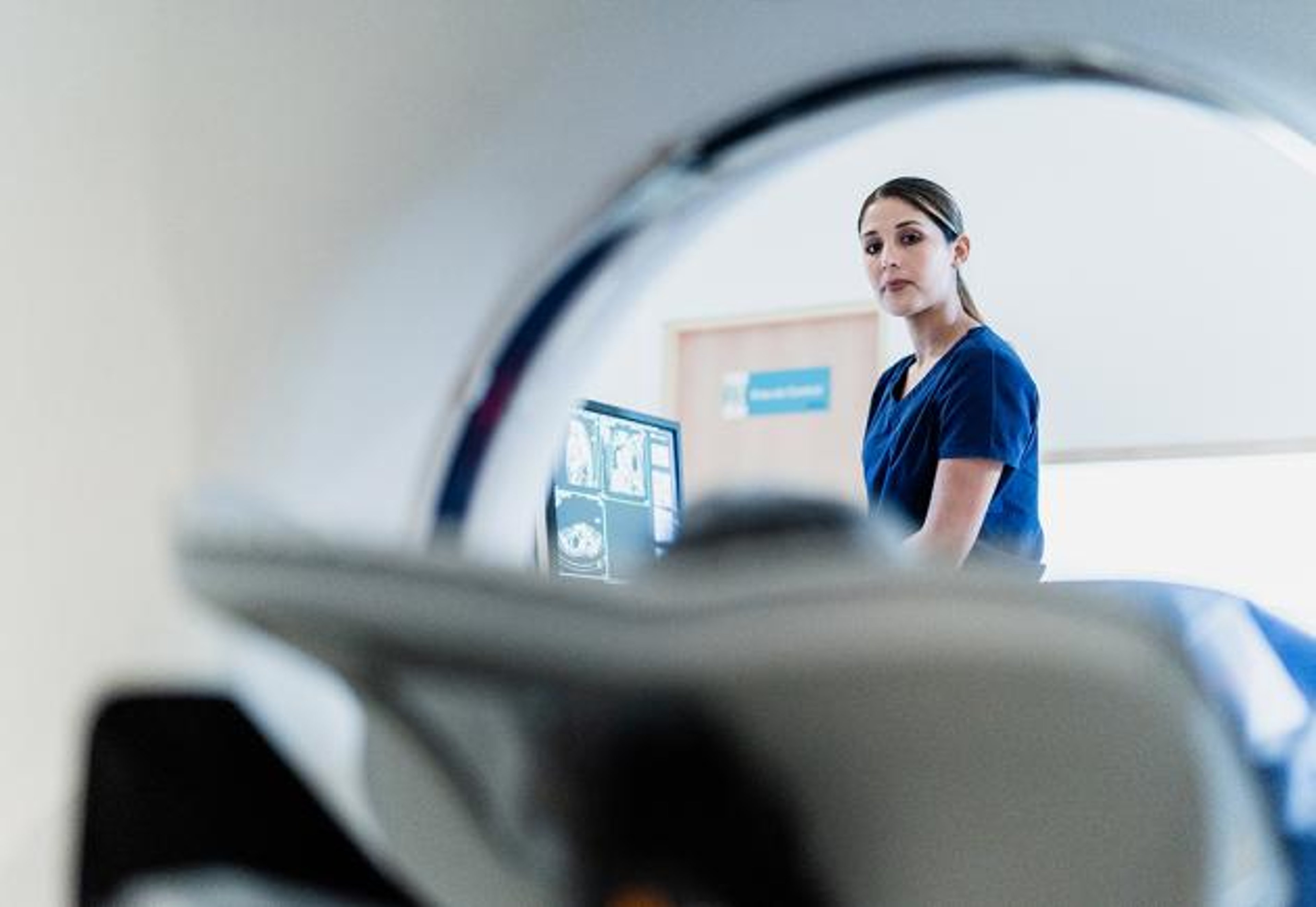 A hospital worker looks on during an MRI.