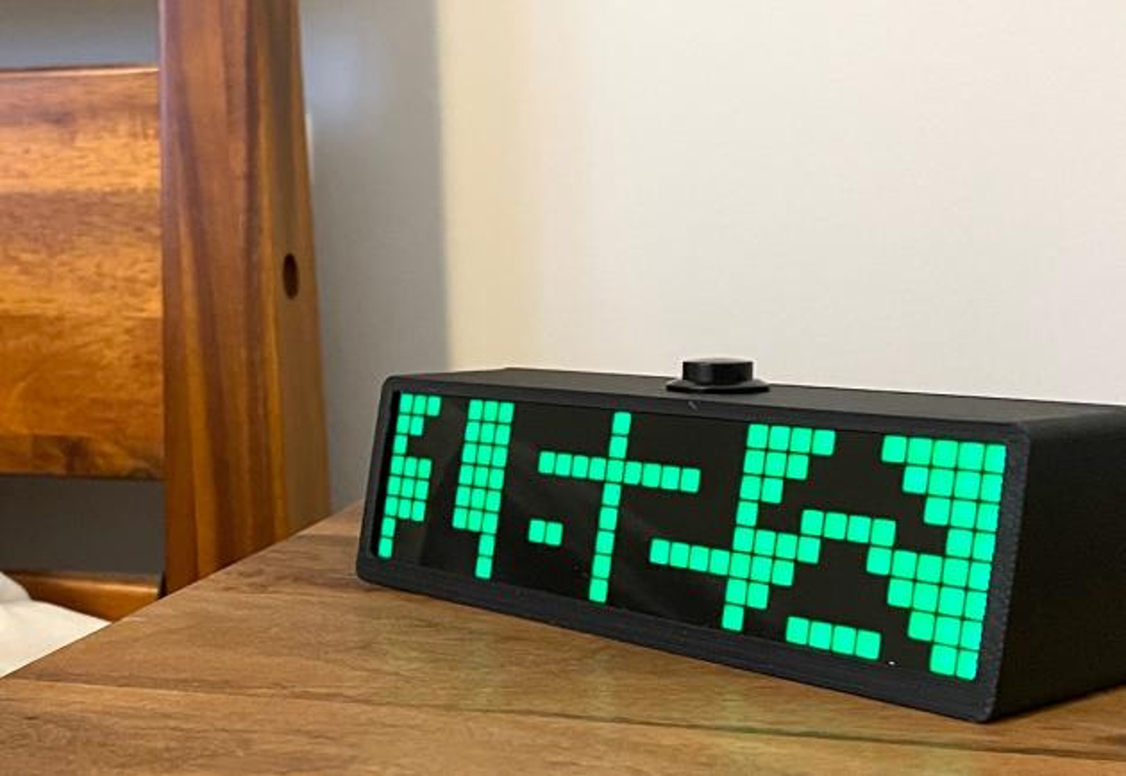The SugarPixel device on a nightstand shows a blood sugar reading of 162 and rising fast.
