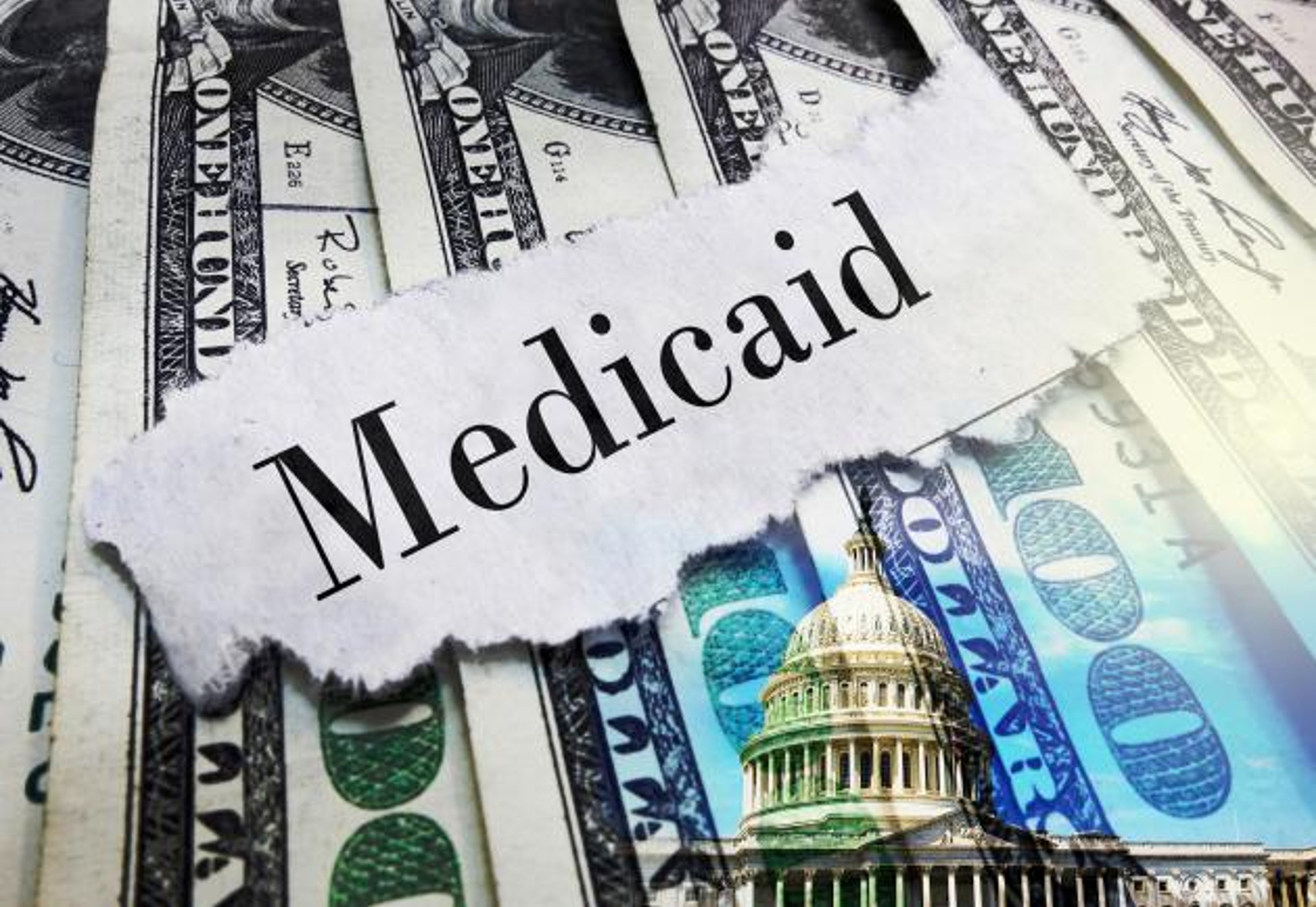 Medicaid newspaper headline on hundred dollar bills with US Capitol in Washington DC