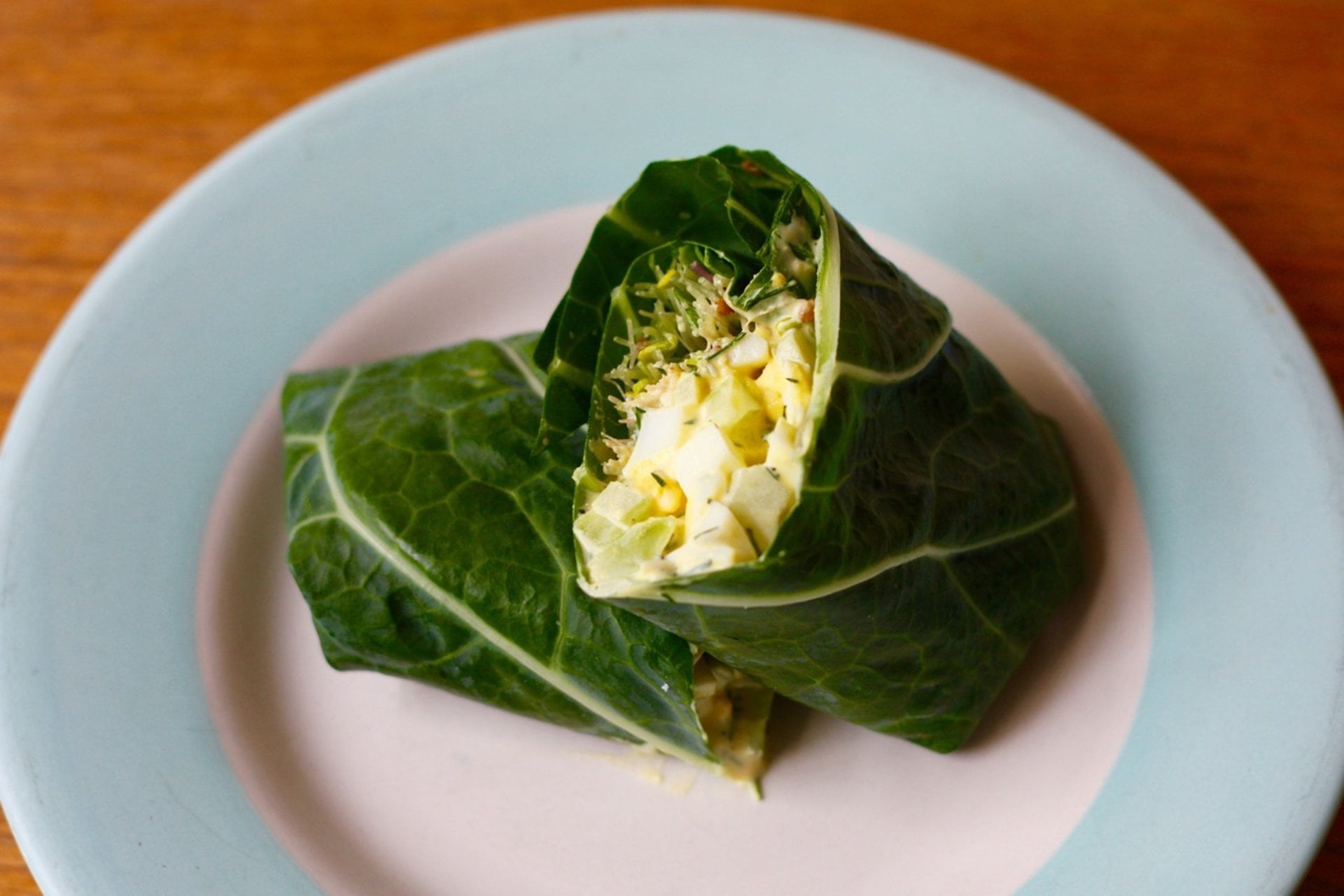 Egg salad-filled collard green wraps on a plate