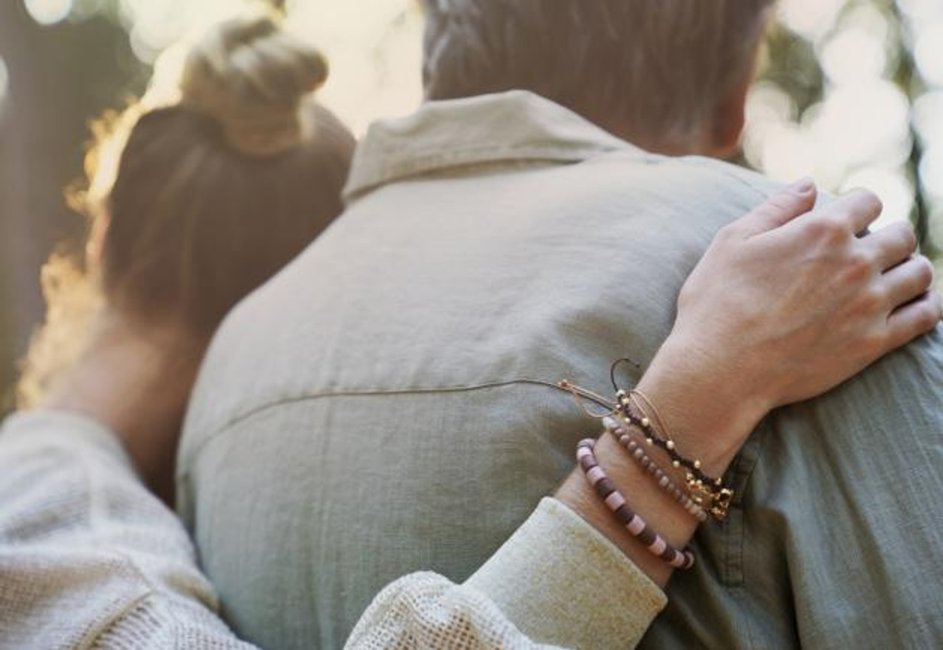 A younger woman and older man embrace.