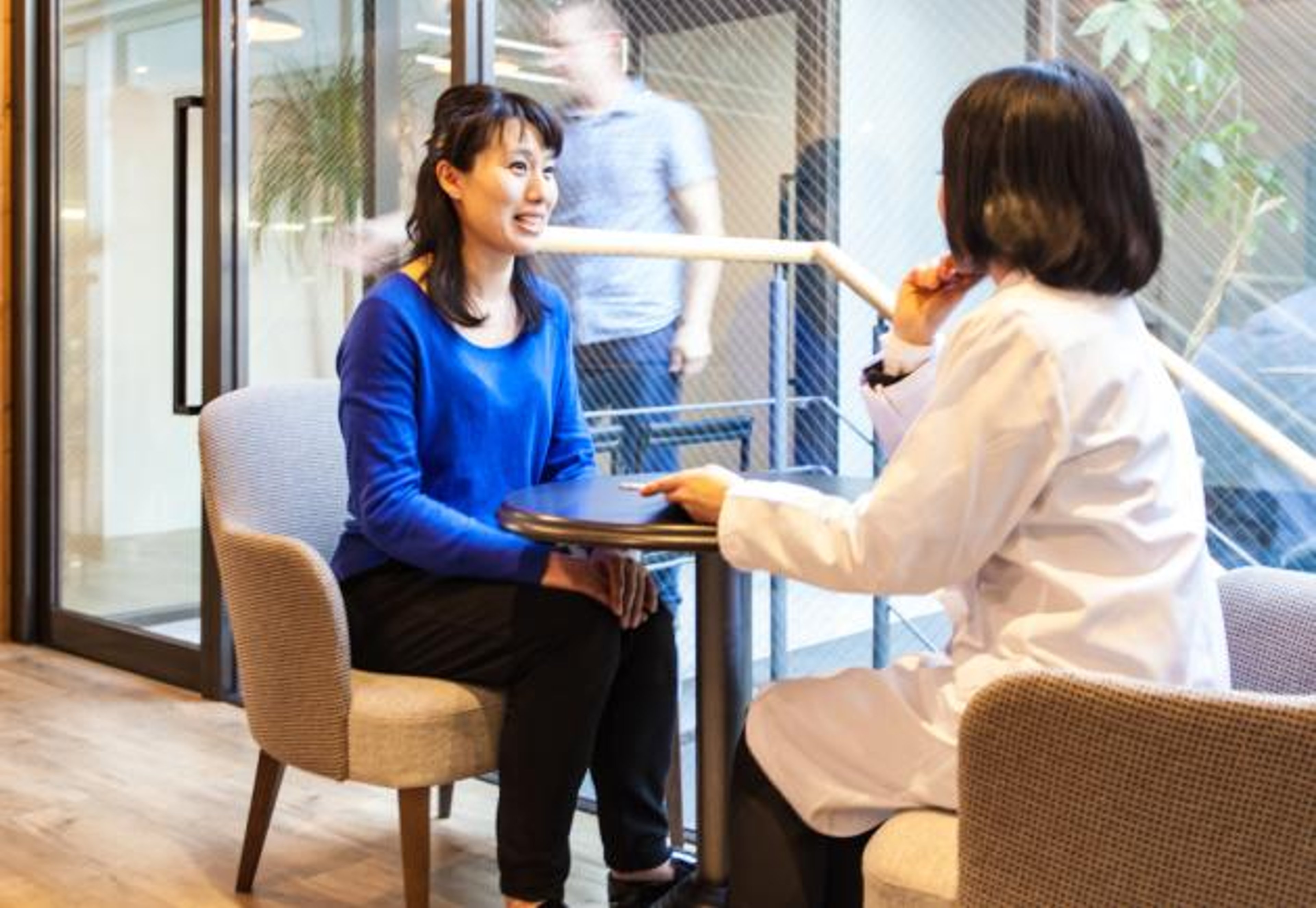 A person in a lab talks with a doctor.