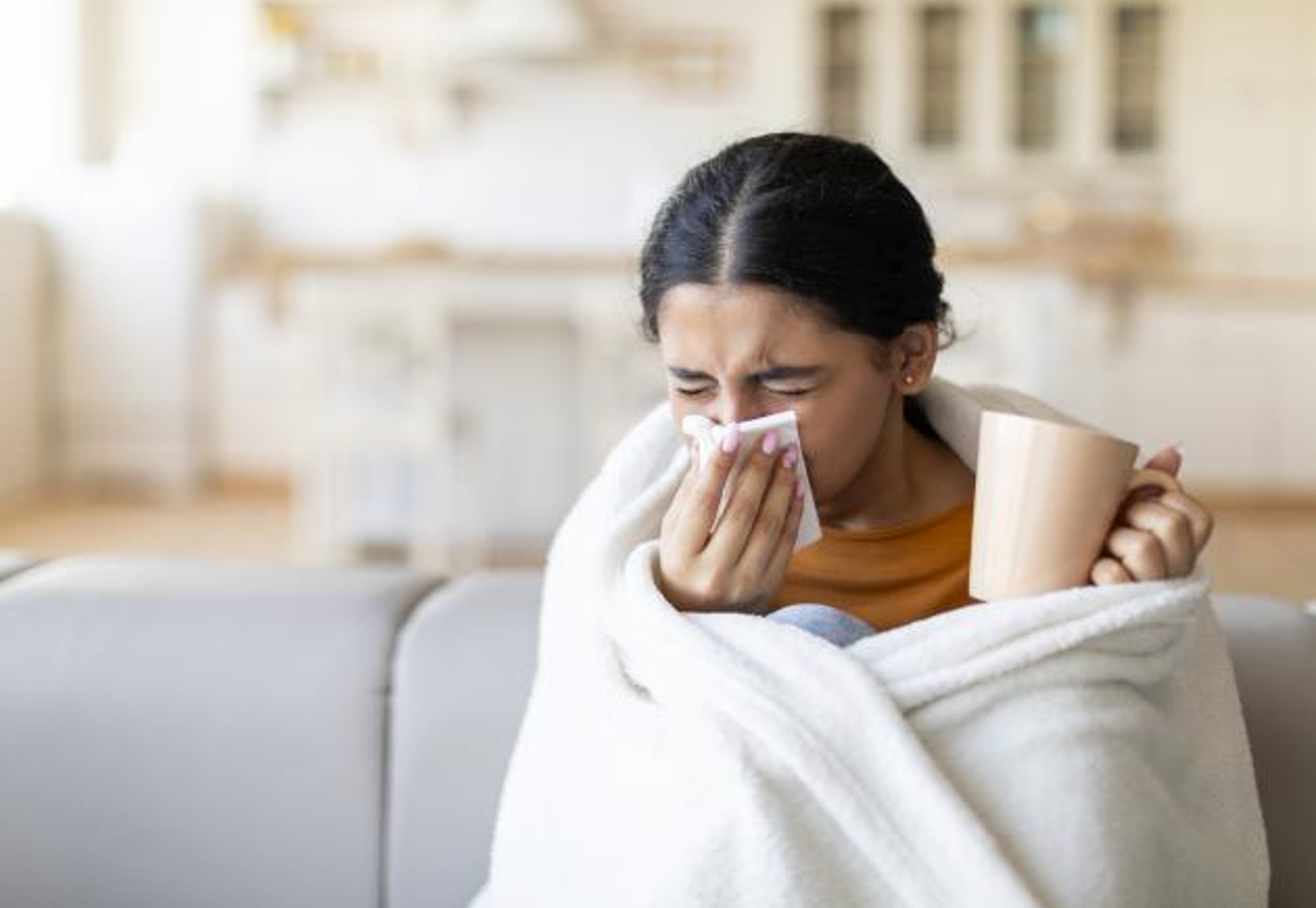 sick young woman blowing nose