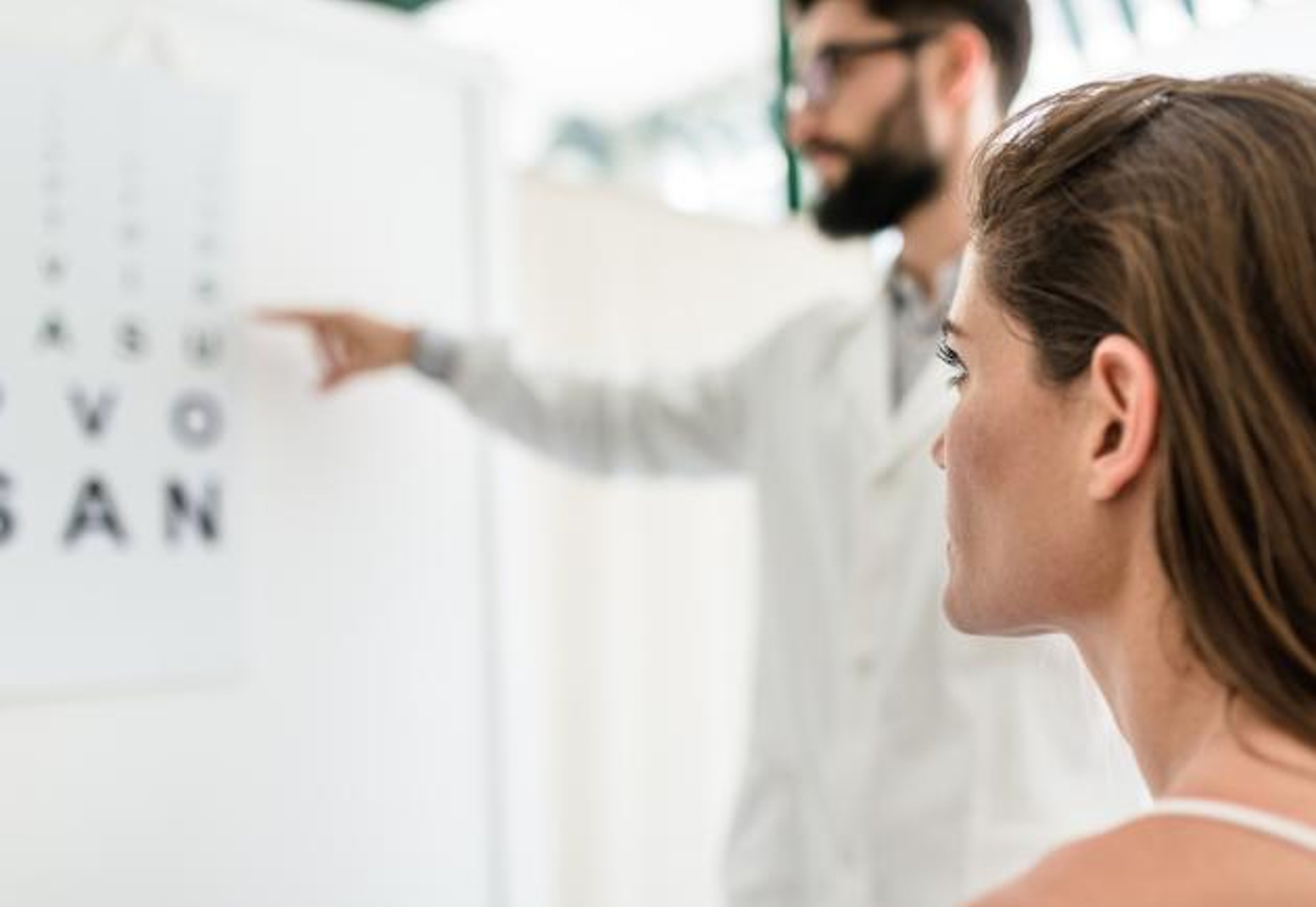 A person in an eye doctor's office views an eye chart. 