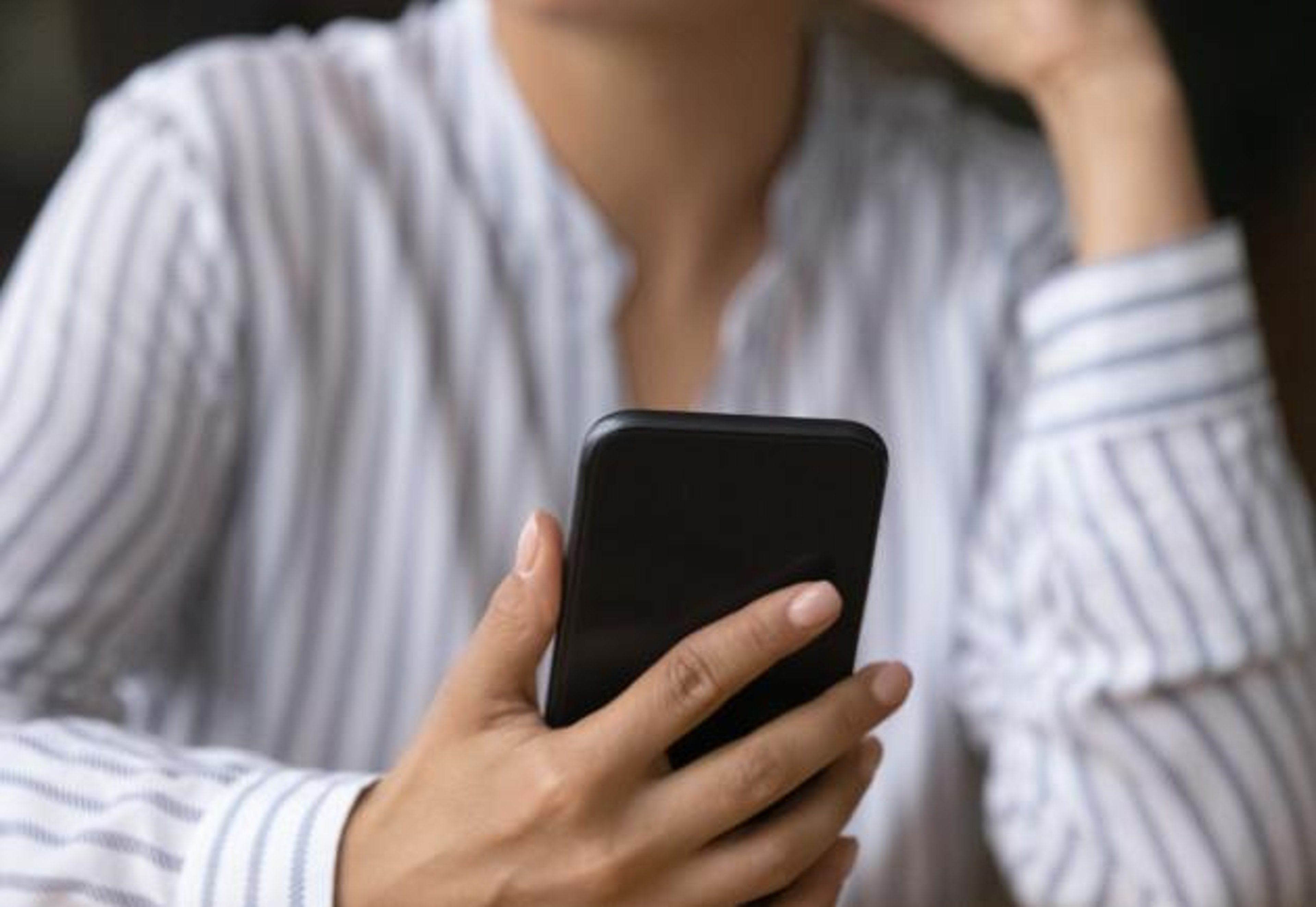 A woman holds a smartphone