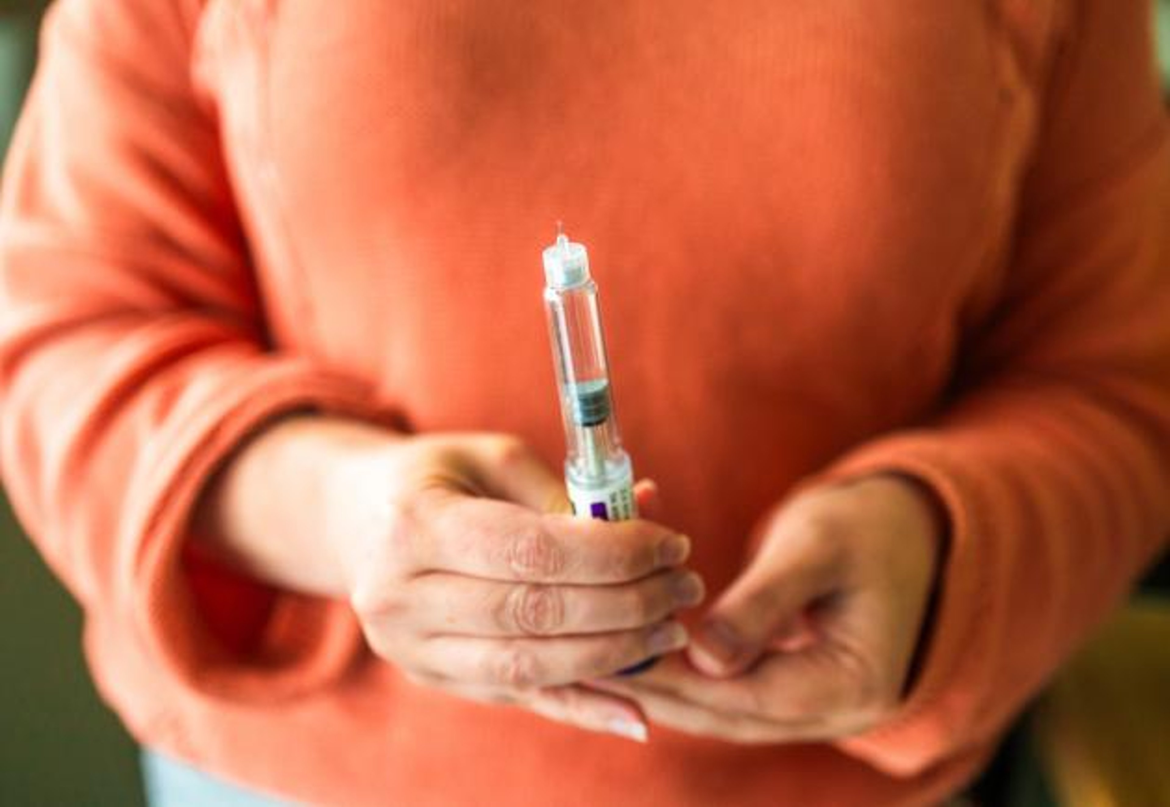 A woman holds a Mounjaro pen