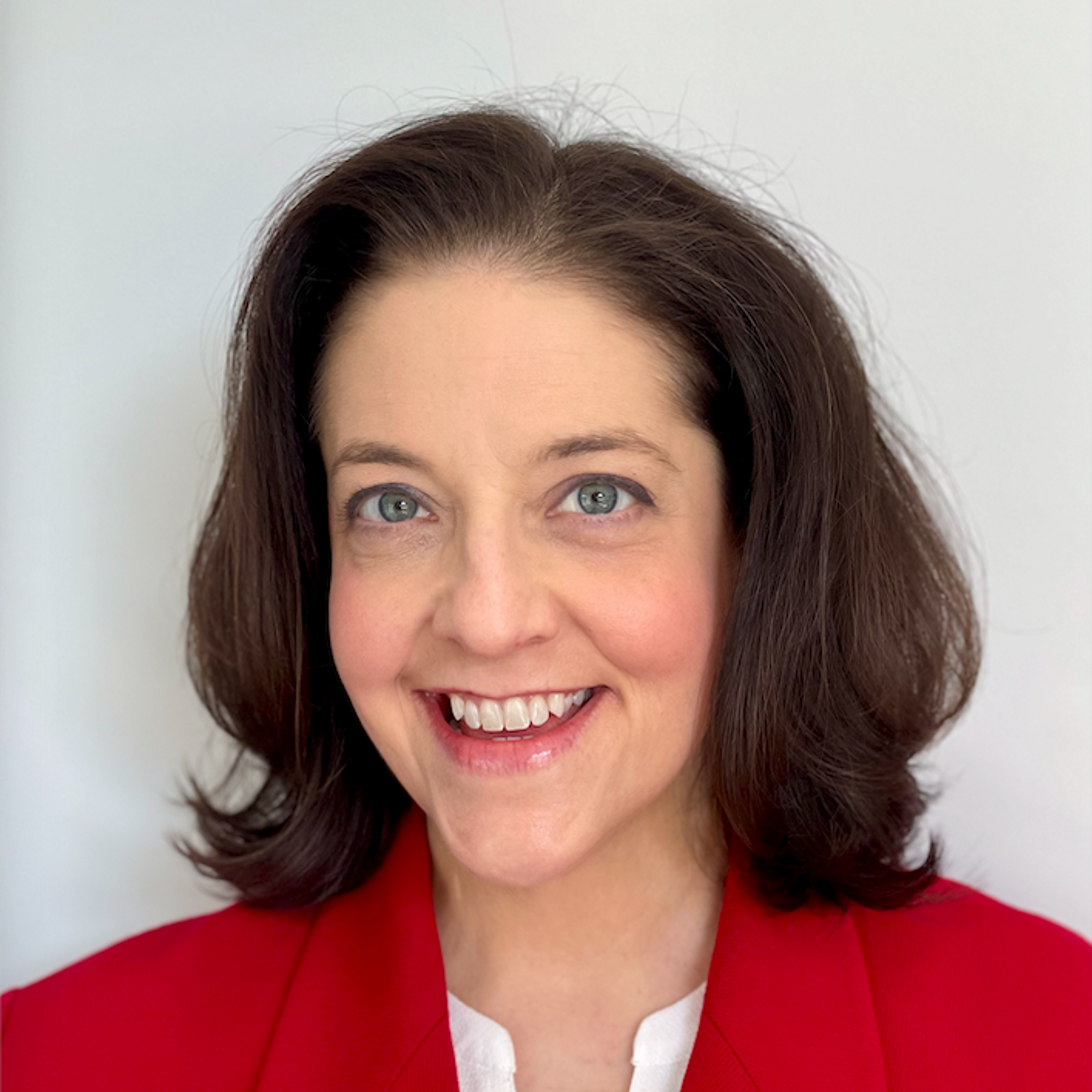 Photo of Julie Heverly, A woman with blue eyes and shoulder length brown hair, wearing a red jacket