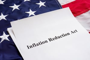 White paper atop a US flag.  The paper says Inflation Reduction Act