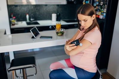 A pregnant woman uses CGM to check her blood sugar