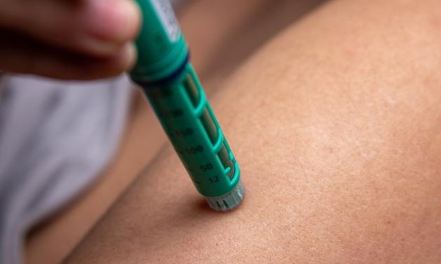 A person injects insulin into their body