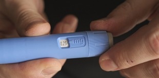 A person examines a semaglutide injection pen